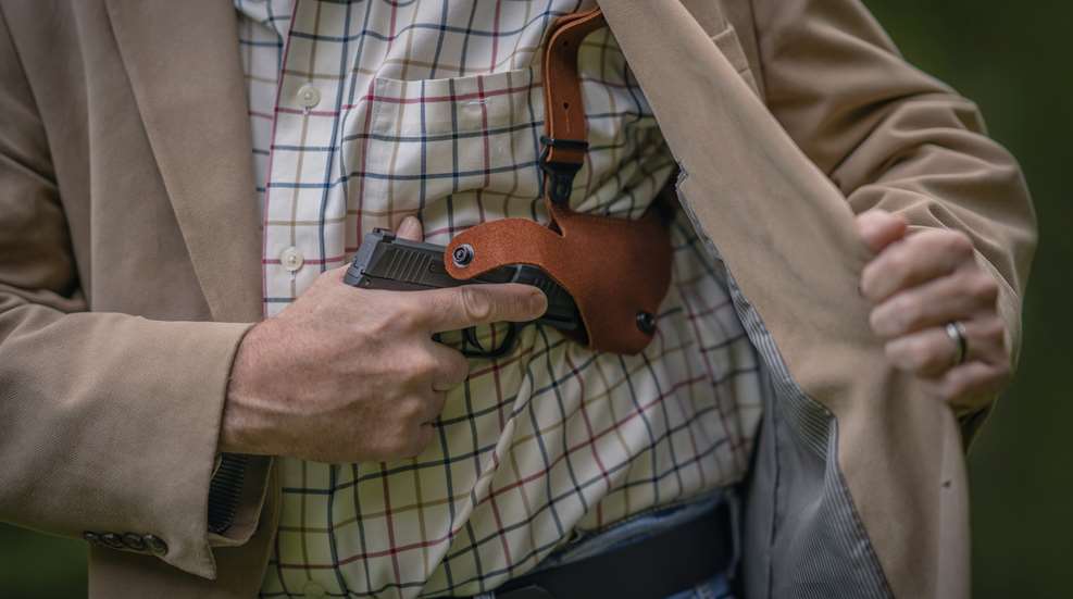 concealed carry gun being pulled out of jacket