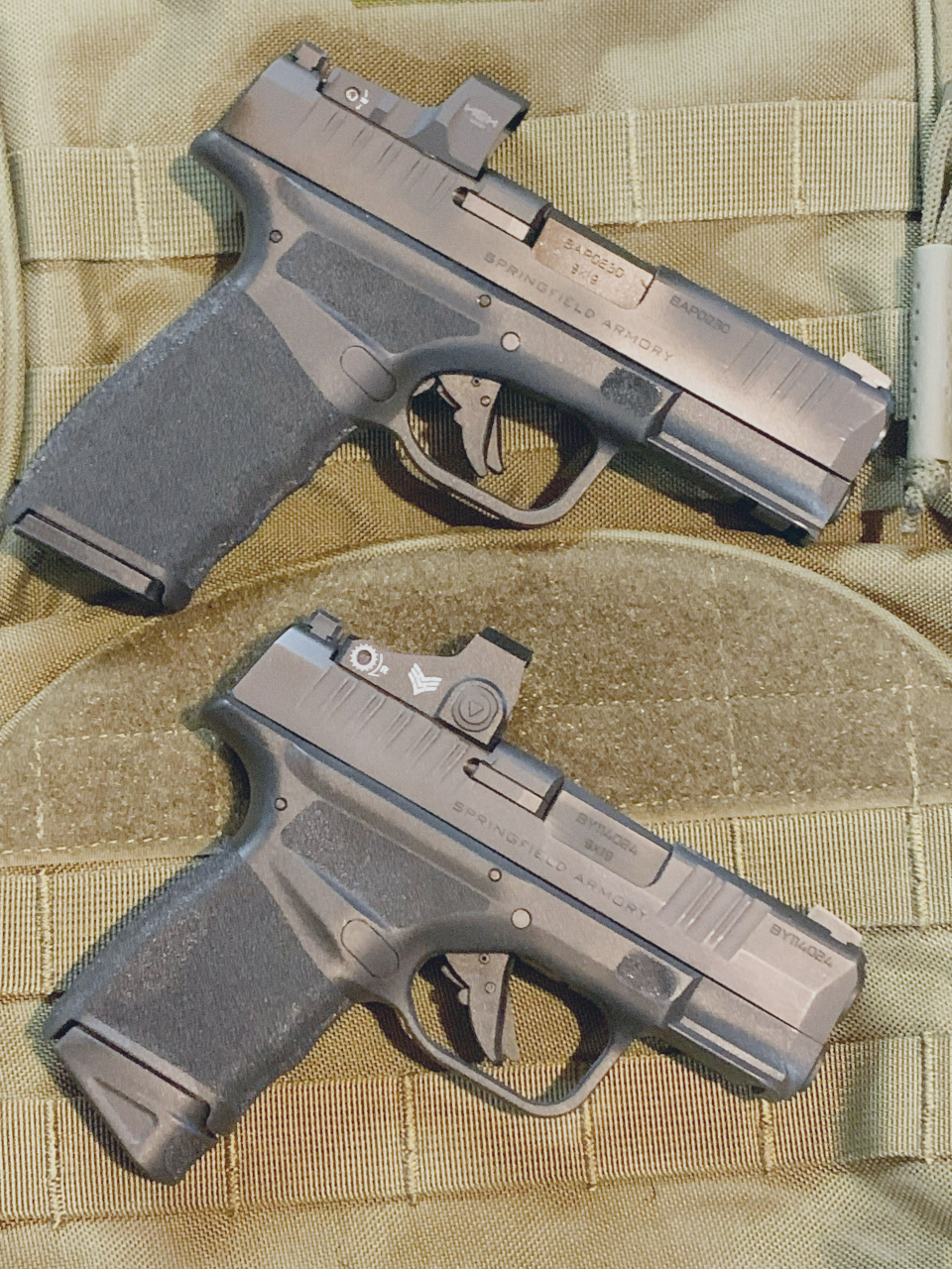 two pistols with red dot sights facing right