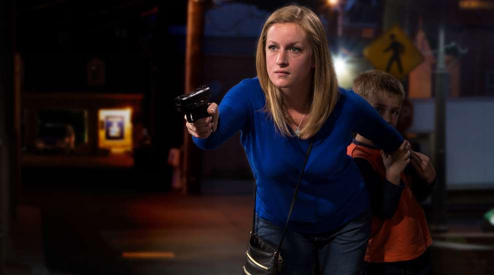 Woman holding handgun with one hand