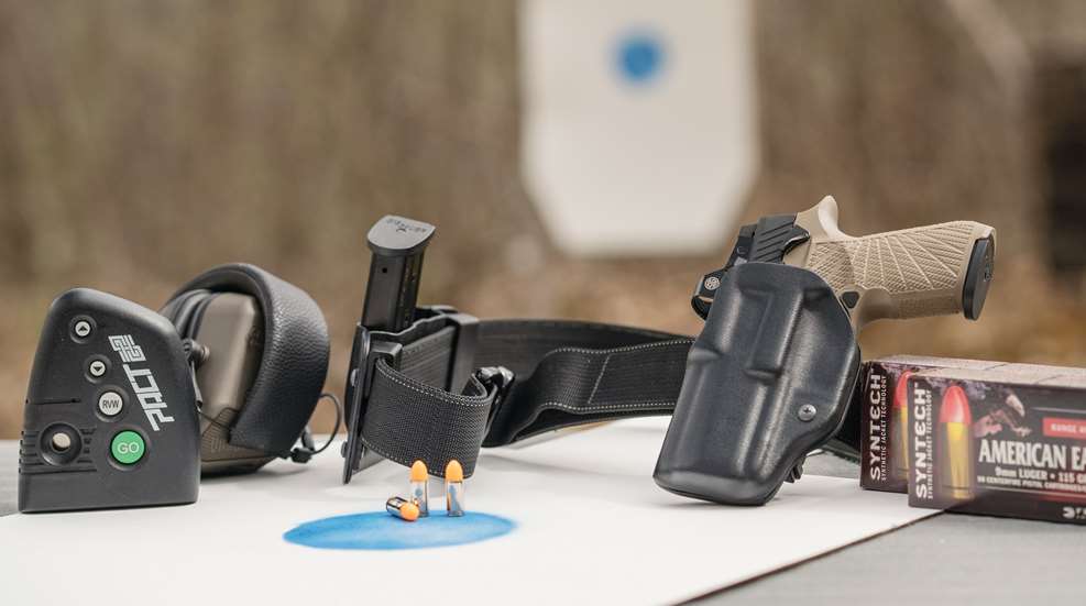 Timer, hearing protection, gun belt and holstered pistol