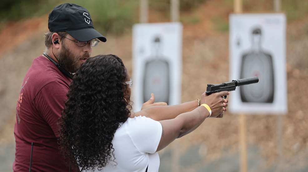 student with trainer at the range