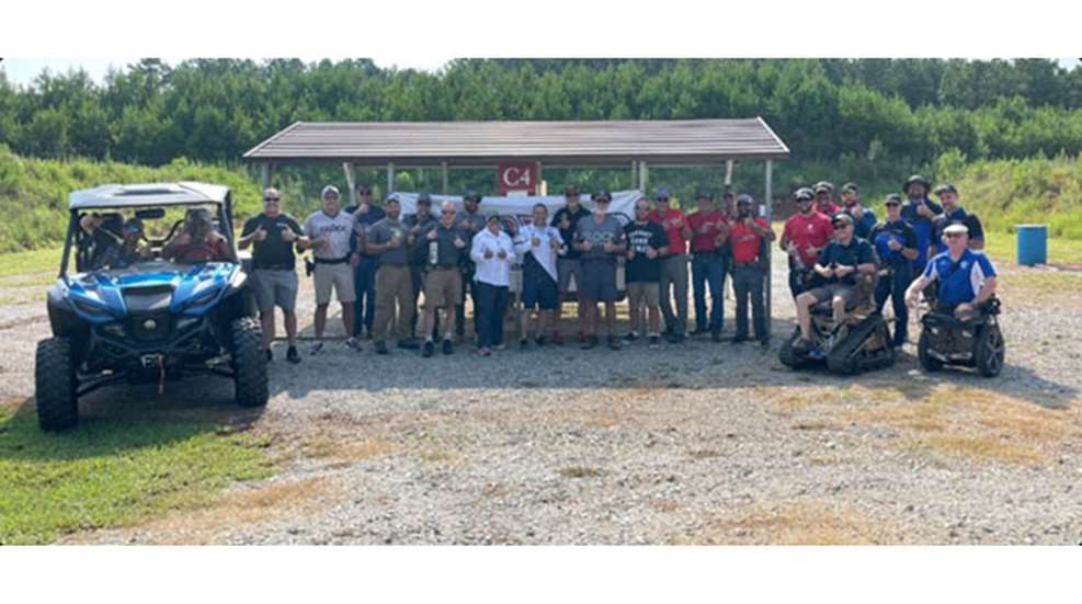 People at shooting range next to ATVs.